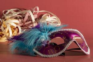 Venetian carnival mask with feathers, and typical elements in the background photo