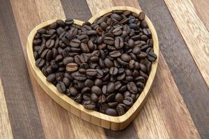 coffee beans in heart-shaped tra,y representing love of coffee photo