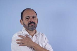 Portrait of 60 years old bearded man on blue background photo