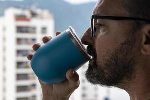 hand holding a mug of water with a view on the city background photo