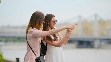 Young positive sisters having fun and making selfie. Concept of friendship and fun with new trends and technology. Best friends saving the moment with their yellow camera video