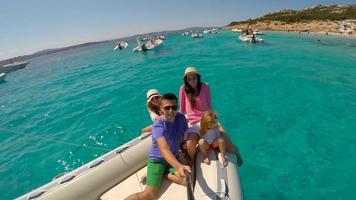 Young happy family with two little girls on a big boat during sammer vacation in Italy