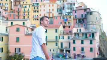 Young tourist man with great view of stunning village of Manarola, Cinque Terre, Liguria, Italy video