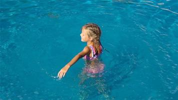 Adorable little girl in outdoor swimming pool video