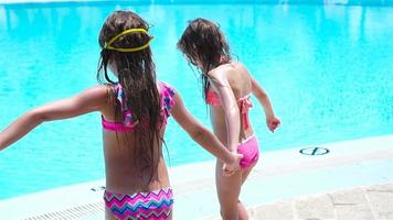 Adorable little girls playing in outdoor swimming pool video