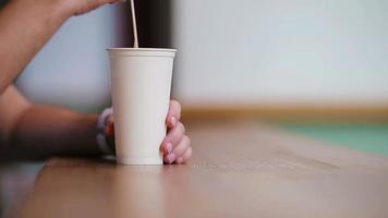detailopname van mannetje handen roeren de suiker in een glas met koffie in cafe. video