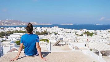 Young boy on street with amazing view on Mykonos, Greece. Beautiful famous background video