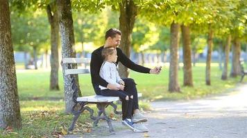 familia feliz en otoño. el padre y el niño se divierten tomándose selfies en un hermoso día de otoño video
