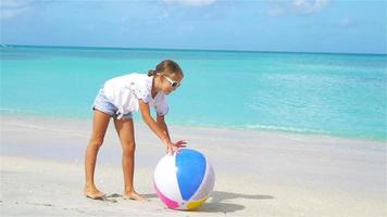 bambina adorabile che gioca sulla spiaggia con la palla video