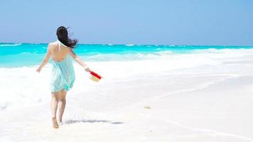 junge schöne Frau am tropischen Strand mit weißem Sand. Rückansicht des kaukasischen Mädchens im Hut Hintergrund das Meer video
