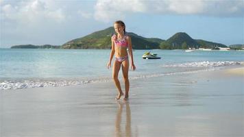 Adorable active little girl at beach during summer vacation video