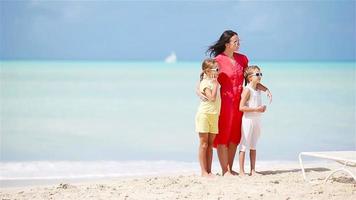 jovem linda mãe e sua adorável filha se divertem na praia tropical video