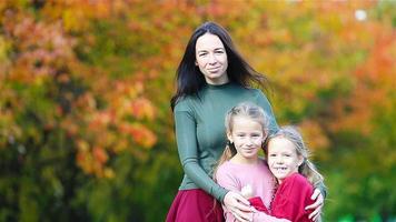 familia de mamá e hijos en otoño. la joven madre y las niñas disfrutan del cálido otoño video