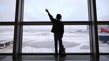 kleines Mädchen im Flughafen in der Nähe des großen Fensters, während es auf das Boarding wartet video