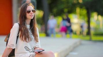 Jeune magnifique fille prendre plaisir écoute la musique et dansant en plein air. magnifique branché femme en utilisant une intelligent téléphone à Ecoutez sa préféré Chansons video