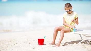 Little adorable girl with sunscreen is protected from the sun video