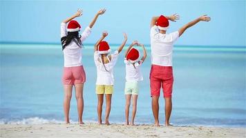 Happy family with two kids in Santa Hat on summer vacation video