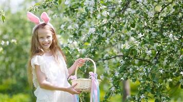 Adorable little girl in blooming apple garden on beautiful spring day video