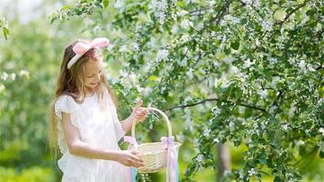 Adorable little girl in blooming apple garden on beautiful spring day video