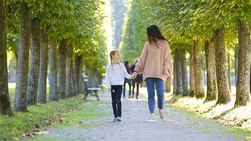 famiglia nel autunno. giovane madre e poco ragazzo a piedi godere caldo giorno nel autunno parco video