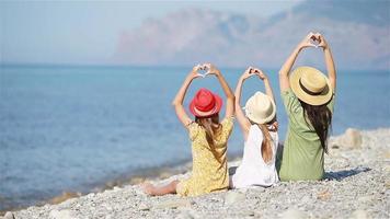 Adorable little girls and young mother on tropical white beach video