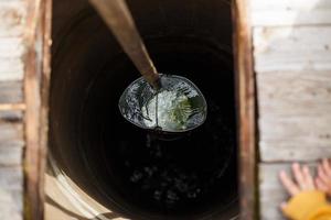 Blue bucked inside water well. A water well with an old iron bucket photo