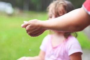 brother and sister play in rainy weather. wet hands close. photo