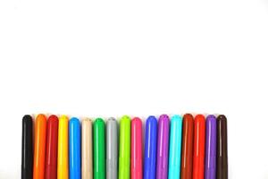 multi-colored felt-tip pens on a white sheet of paper. felt-tip pens on a white background photo