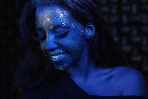 Young beautiful girl with blue face painting photo