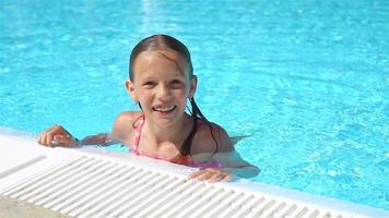 aanbiddelijk weinig meisje zwemmen Bij buitenshuis zwemmen zwembad video