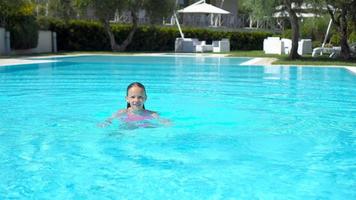 adorable niña nadando en la piscina al aire libre video