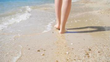 schönes kleines Mädchen im Kleid am Strand, das Spaß hat. lustiges mädchen genießt sommerferien. video