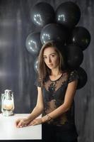 Pretty young brunette posing near a table photo