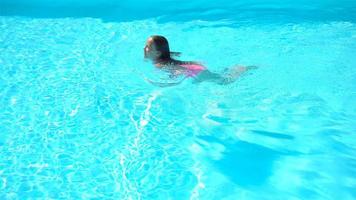 adorable niña nadando en la piscina al aire libre video