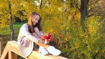 Portrait of adorable little girl with yellow leaves bouquet in fall video