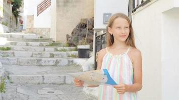 Adorable little girl with map of european city outdoors video