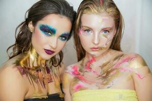 Two cute young women with creative make-up photo