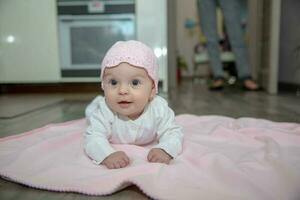 hermosa pequeño bebé mentiras en un rosado tartán foto