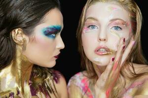 Two alluring young women with creative make-up photo