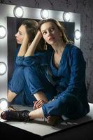 Pensive woman dressed in denim overalls photo