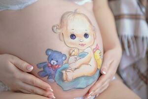 Pretty drawing on the stomach of a pregnant woman photo