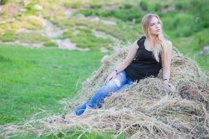 Pretty lady posing sitting on the hay photo