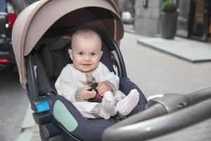 Happy little baby sitting in a stroller photo