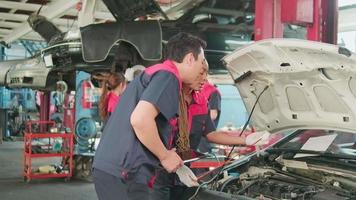 masculino profissional automotivo Supervisor aconselha e inspeciona Preto fêmea mecânico trabalhador sobre líquido motor óleo às carro garagem, serviço manutenção, e fixação especialista ocupações auto indústria. video