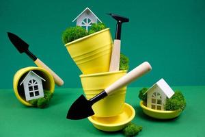 Creative photo on a green background with yellow flower pots and garden tools