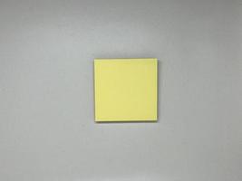 Yellow sticky note block on gray background photo