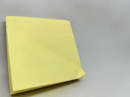 Yellow sticky note block on gray background photo