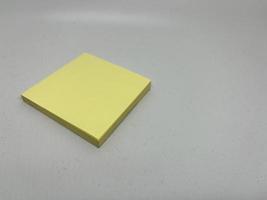 Yellow sticky note block on gray background photo