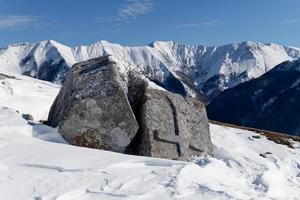 Stecci Medieval Tombstones Graveyards in Lukomir village, Bosnia and Herzegovina. The tombstones feature a wide range of decorative motifs and inscriptions. Winter and snow. photo