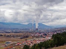 Thermal power station expelling pollutants to the air. City with poor air quality due to thermal power plant. Burning fossil fuel. Toxic air for people in the cities. photo